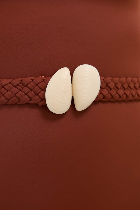 Marsala The Classic One Piece showcases a sleek, strapless design with a removable braided belt and shell clasp, embodying effortless high-end style and playful elegance.