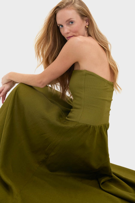 Woman in a classic, olive-green, strapless Green Empowerment Movement Ankle Skirt, showcasing its versatile, high-end design as both a dress and skirt.