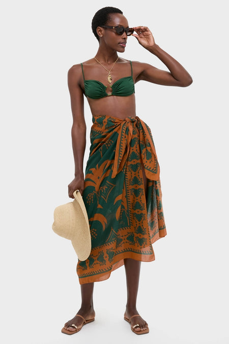 Woman wearing the Rust and Dark Green Dance of Pareo, paired with a classic bikini top, showcasing an effortless, high-end style with a fun, confident vibe.