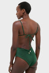 Woman from behind in the Sumatra Green Tangle Up Bikini Top, featuring adjustable straps, beaded details, and a bow tie, embodying classic, effortless, high-end style.