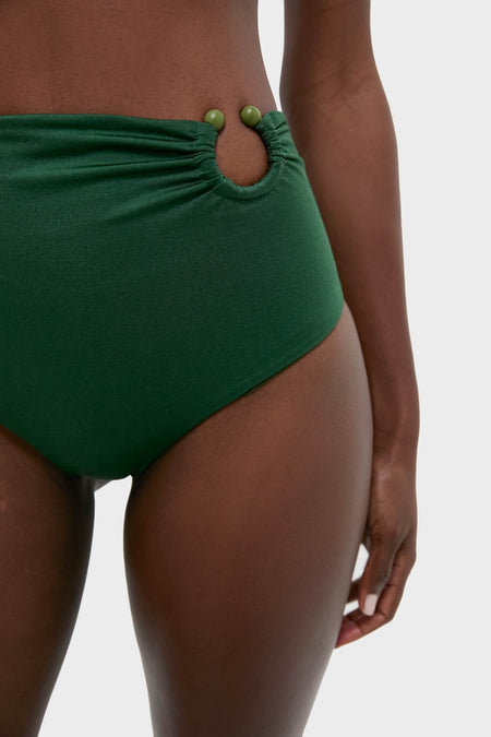 Sumatra Green Taita Bikini Bottom, high-waisted with a classic cut and playful bead-accented hip cut-out, embodies effortless style, enhancing confidence and fun for any high-end beach outing.