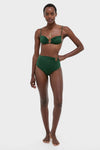 Woman modeling Sumatra Green Taita Bikini Bottom, high-waisted with elegant ring accent, paired with matching top. Classic, effortless style perfect for high-end, fun beachwear.