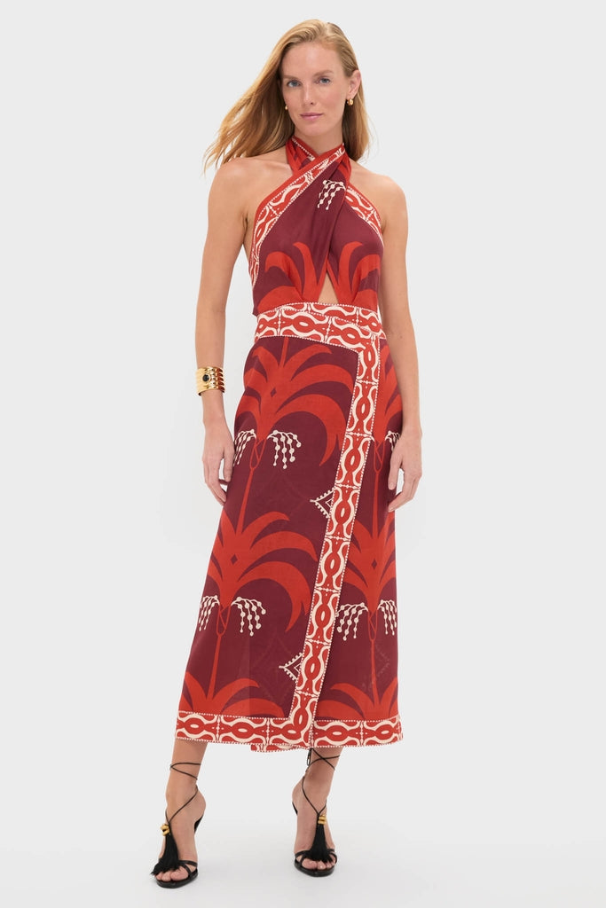 Woman models the Wine and Red Buen Viento Ankle Dress, featuring a classic halter-neck design with bold motifs, paired with black strappy heels and gold accessories for an effortless, high-end look.