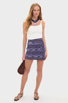 Woman in an effortless classic summer look wearing the Navy and Ecru Hunting Roots Wrap Skirt with geometric motifs and a playful low-rise, mini design.