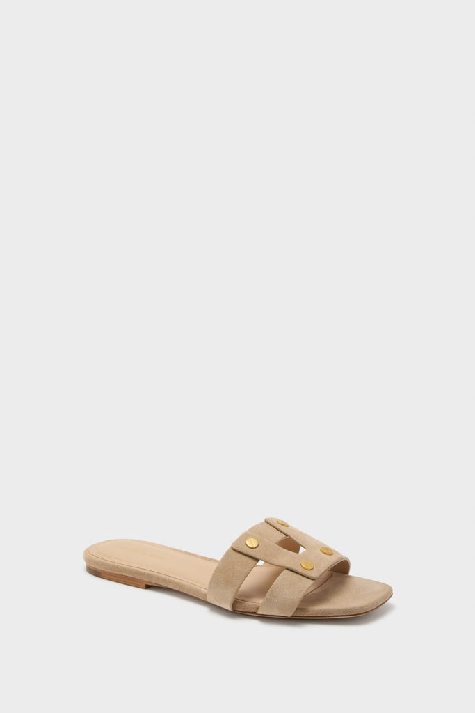 Classic and effortless, the Sand Via Slides feature a taupe suede “H” cutout design with gold stud accents, offering a fun and high-end look.