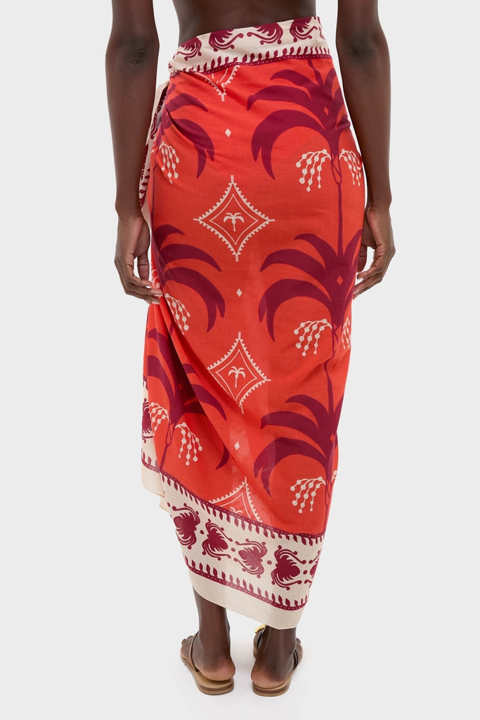 Back view of a person wearing the Red, Ecru, and Dark Cherry Dance of Pareo, a classic, effortless wrap-style skirt with bold palm-tree motifs, exuding fun, high-end style.