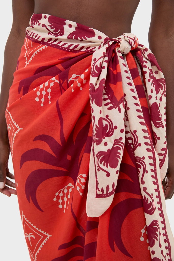 The Red, Ecru, and Dark Cherry Dance of Pareo features classic floral motifs, effortlessly tied at the hip, offering a fun and high-end style statement.