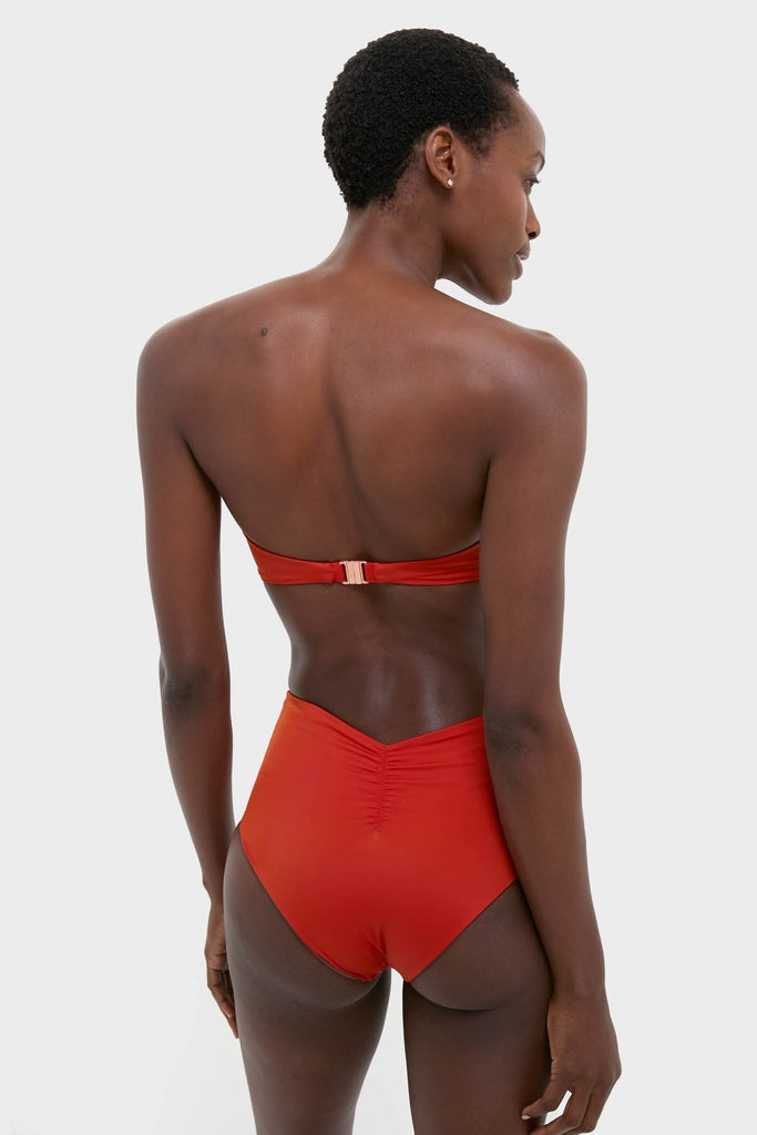 Back view of a person in a Fire Red Sea Sprite Bikini Top, featuring a classic bandeau silhouette with a twist-front design, conveying effortless, fun, and high-end style.