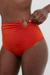 Model wearing Fire Red Taita Bikini Bottoms, showcasing classic high-rise design with effortless ruching and fun bead accents, embodying Tuckernuck's high-end, confident style.