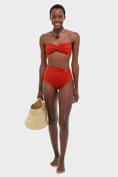 Young woman models the classic Fire Red Taita Bikini Bottom with flattering high-rise and bead detail, paired with a bandeau top, exuding effortless, high-end vacation style.
