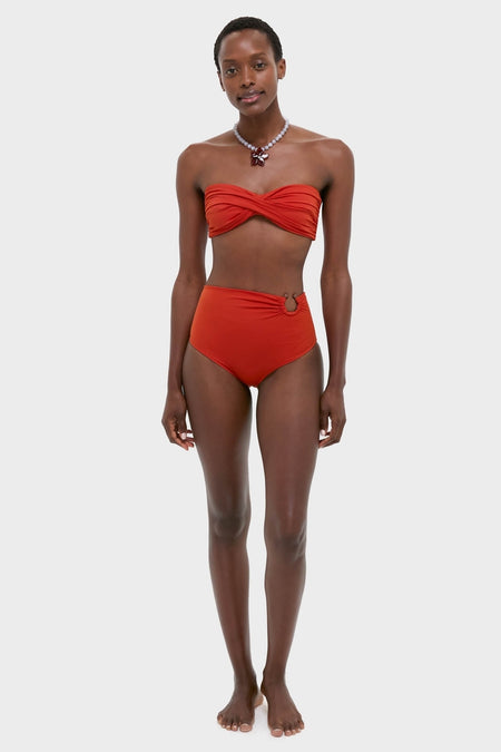 Woman models Fire Red Taita Bikini Bottom, featuring a classic high-rise silhouette with ruching and bead accent, paired with a twist-front bandeau top for an effortless, high-end look.