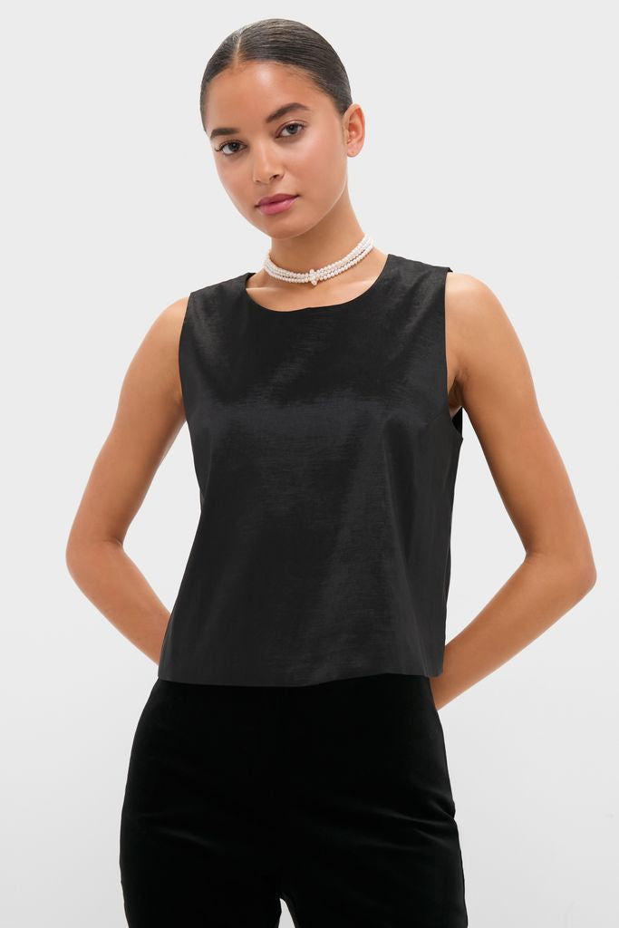 Woman in chic Black Taffeta Keating Top, featuring a sleeveless, boxy silhouette and elegant pearl-style necklace, embodying effortless, high-end style.
