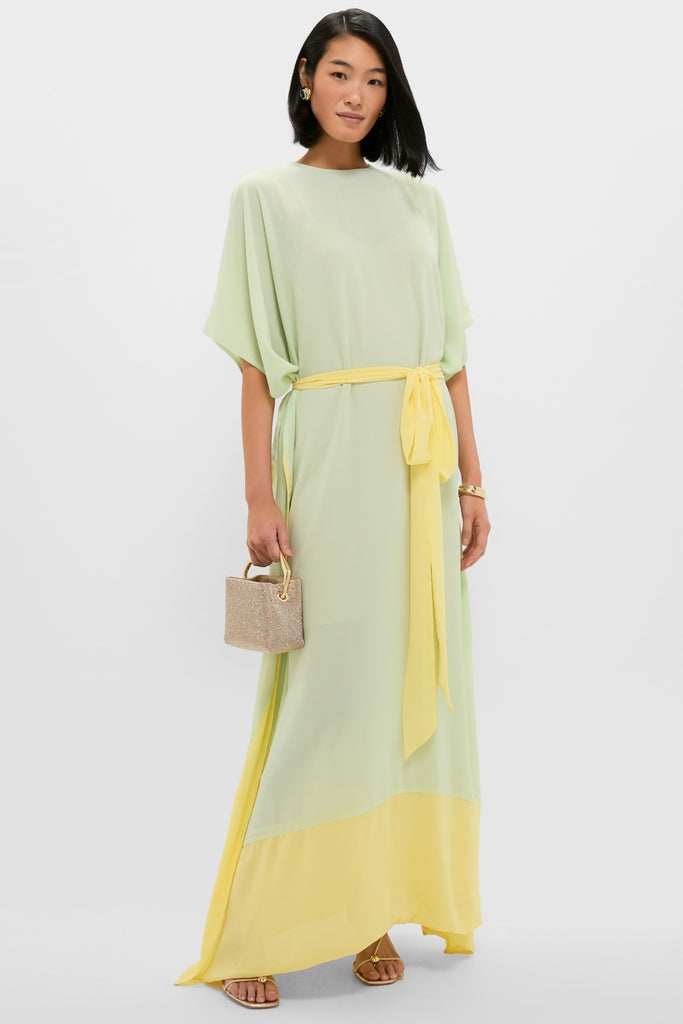 Woman in a classic Mint Chiffon Caftan Gown with citron hem and tie, accessorized with gold jewelry and a box handbag, exuding effortless, high-end style.