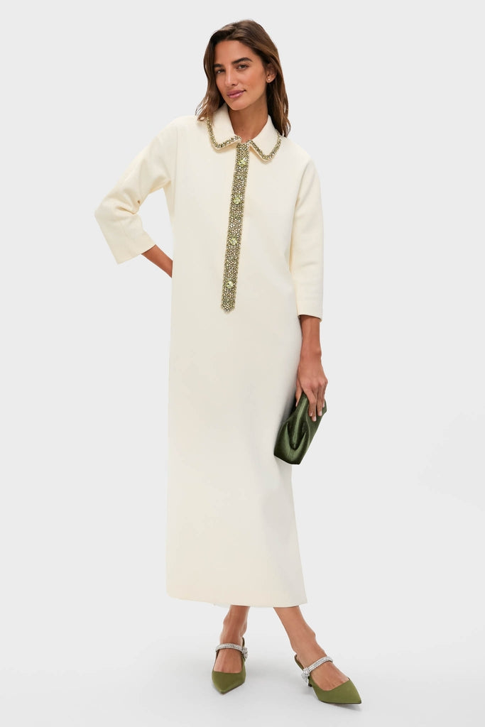 Model wearing the Winter White Embellished Nicola Maxi Dress, featuring jeweled accents, paired with an olive-green clutch and slingback heels, embodying a classic, effortless, high-end look.
