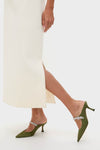 Model wearing the Winter White Embellished Nicola Maxi Dress, featuring a classic, effortless cream skirt with a side slit, paired with fun, high-end olive-green mule heels.