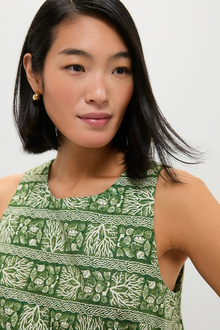 Woman wearing the Cowrie Block Print Keating Top, featuring classic coral-and-shell motifs. Paired with gold hoop earrings for an effortless, high-end look.