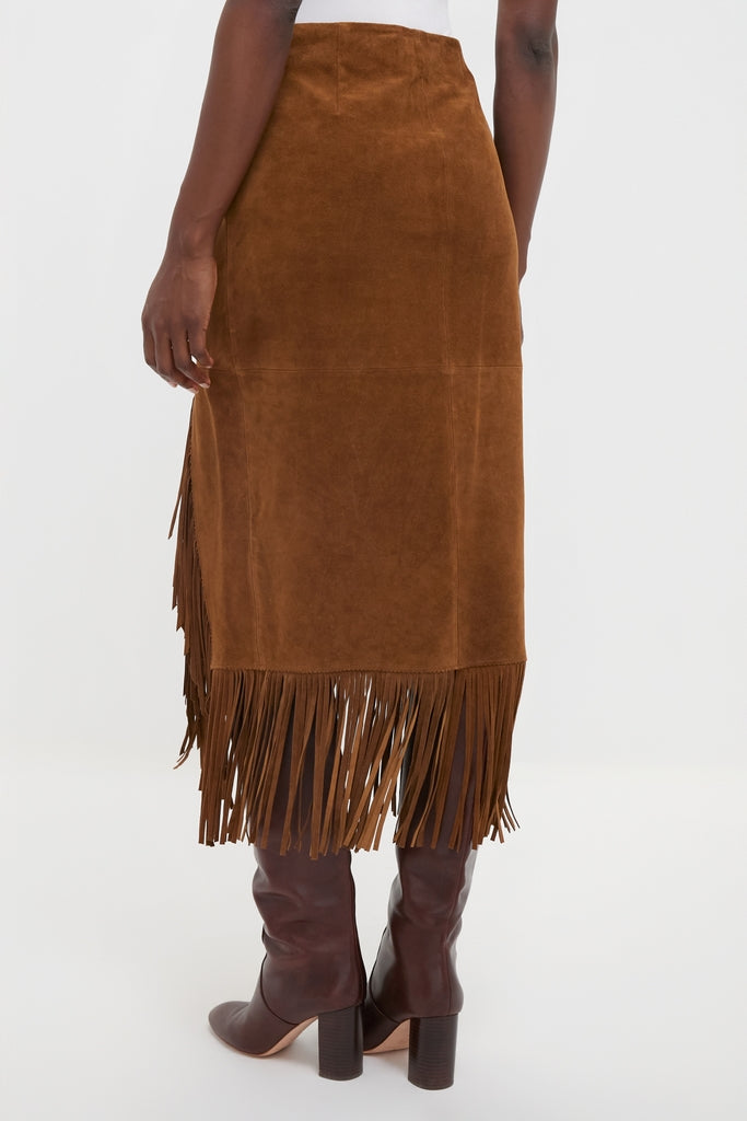 Woman wearing the Clove Calf Roughout Suede Midi Skirt, featuring classic long fringe and a side slit, paired with knee-high boots for an effortless, high-end look.