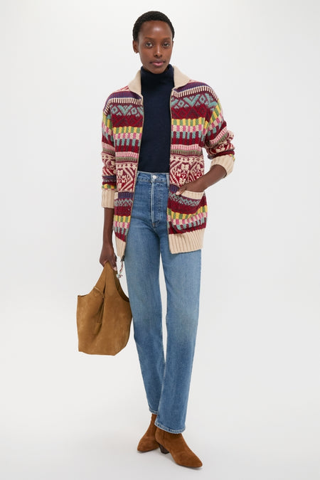 Model wearing a classic, fun Brick Multi Cotton Wool Blend Sweater by Polo Ralph Lauren, paired with effortless jeans and high-end suede booties, embodying Tuckernuck's cool style.
