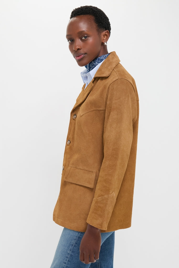 Model wearing the Maple Cow Roughout Suede Jacket, showcasing a classic, effortless style with notch lapels and patch pockets. Paired with a light blue shirt and blue jeans.