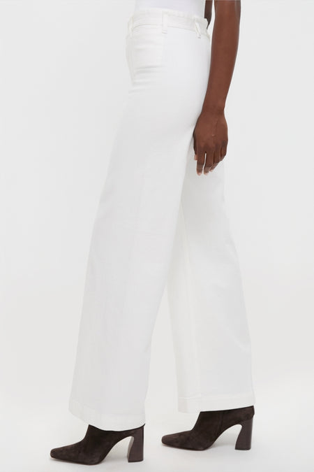 Model wears Nevis Cotton Twill Woven Standard Flare Pants, showcasing classic high-rise, wide-leg denim with effortless style, paired with fun, high-end suede ankle boots.