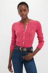 Woman wearing classic, fitted Nantucket Red Cardigan with cable-knit detailing and embroidered logo, paired with high-waisted jeans and a leather belt for an effortless, high-end look.