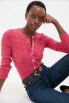 Young woman models the Nantucket Red Cardigan, a classic, cable-knit design with button-front and embroidered logo, paired effortlessly with jeans for a high-end, fun look.