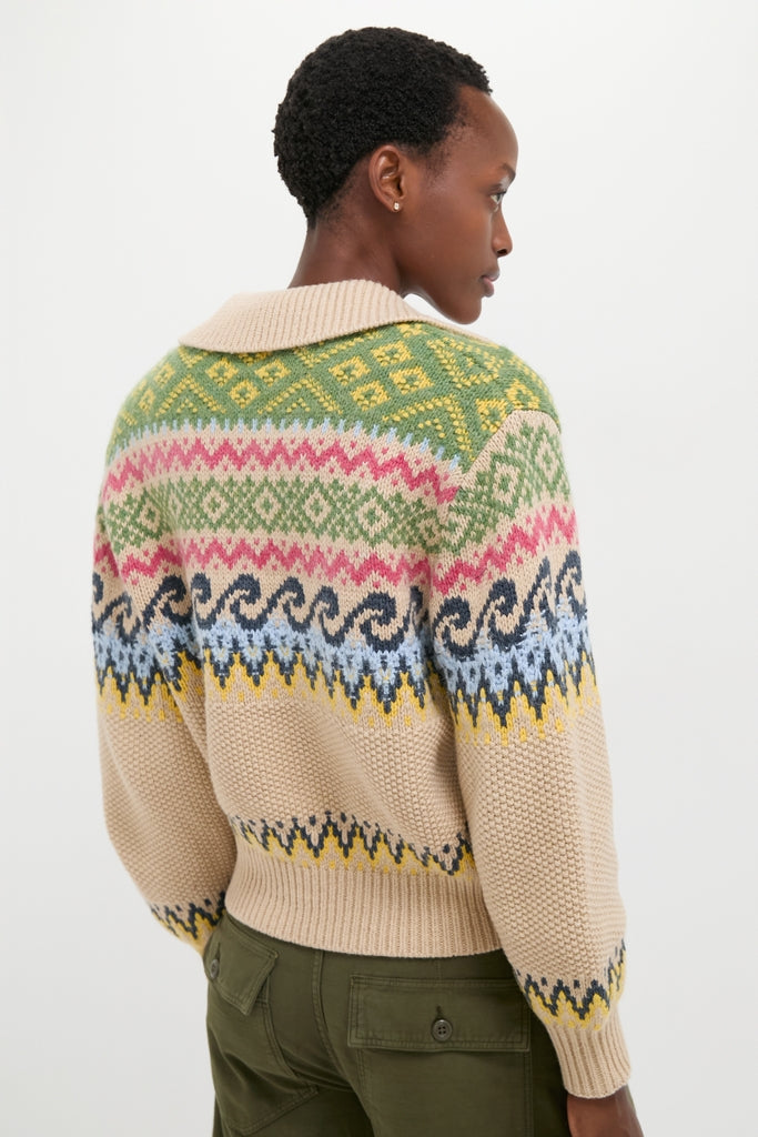 Back view of a person in a Tan Multi Cotton Wool Blend Long Sleeve Tie Pullover featuring a classic, multicolored Fair Isle pattern, paired with olive-green pants for an effortless, high-end look.