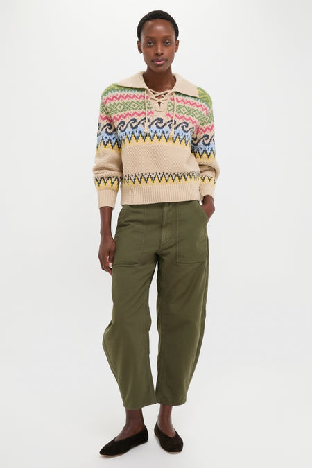 Woman in a classic, high-end Tan Multi Cotton Wool Blend Long Sleeve Tie Pullover, paired with effortless olive-green cropped trousers and dark flat shoes, embodying fun and timeless style.