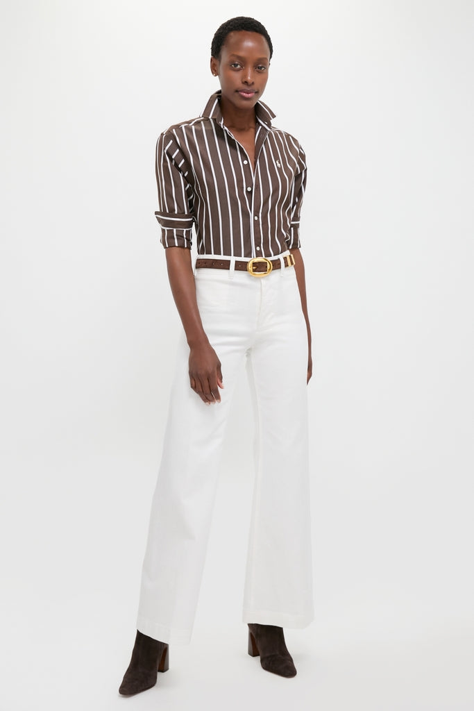 Model in a classic Dark Brown and White Stripe Long Sleeve Button Down, paired with high-waisted white trousers and suede ankle boots, exuding effortless, high-end style.