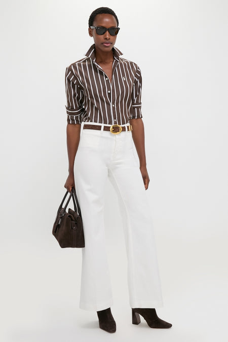 Model in a classic, effortless Dark Brown and White Stripe Long Sleeve Button Down, paired with high-waisted pants and accessories, embodying a fun, high-end style.