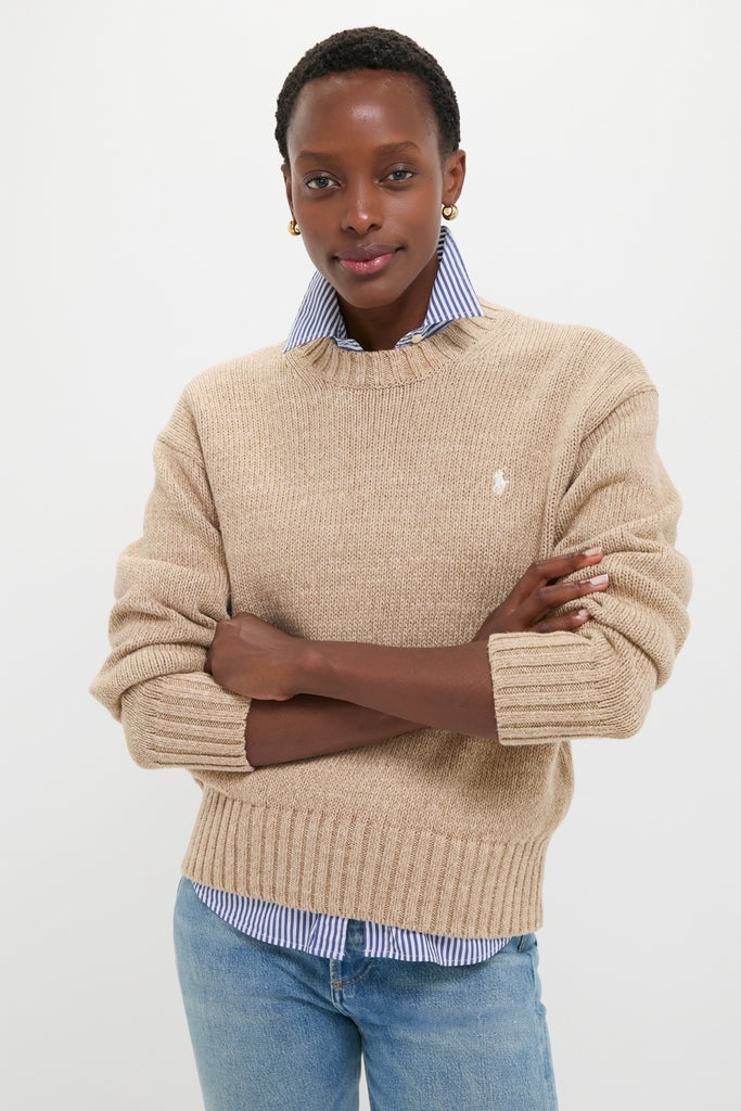 Model in a classic Tan Heather Cotton Long Sleeve Crewneck, layered over a striped shirt, styled with jeans for an effortless, high-end, and fun look.