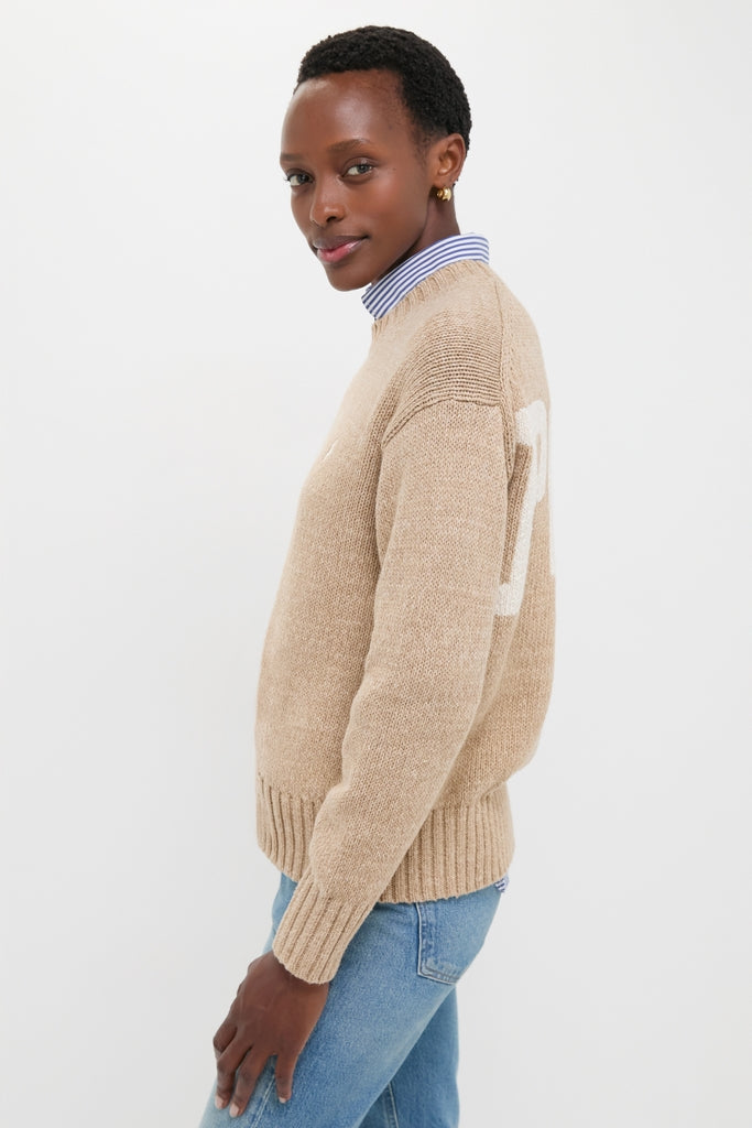 Tan Heather Cotton Long Sleeve Crewneck on dark-skinned person, styled effortlessly with a collared shirt and jeans, showcasing classic, high-end, and fun Tuckernuck appeal.