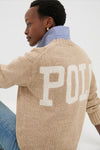 Person wearing a Tan Heather Cotton Long Sleeve Crewneck by Polo Ralph Lauren with POLO on back, styled over a striped shirt and jeans for an effortless, classic look.
