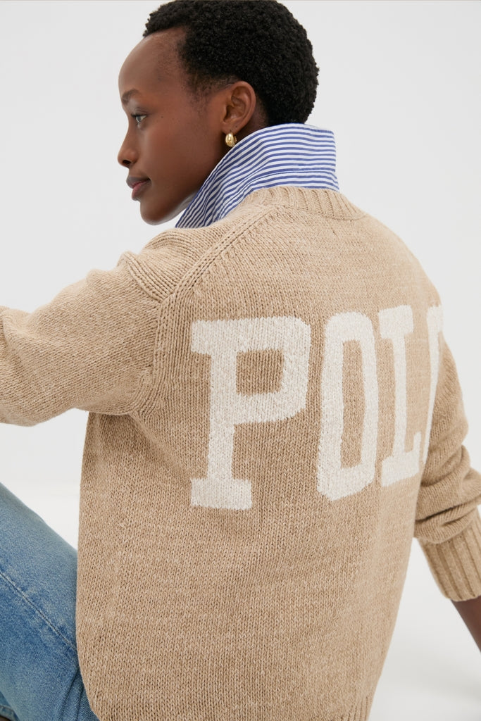 Person wearing a Tan Heather Cotton Long Sleeve Crewneck by Polo Ralph Lauren with POLO on back, styled over a striped shirt and jeans for an effortless, classic look.