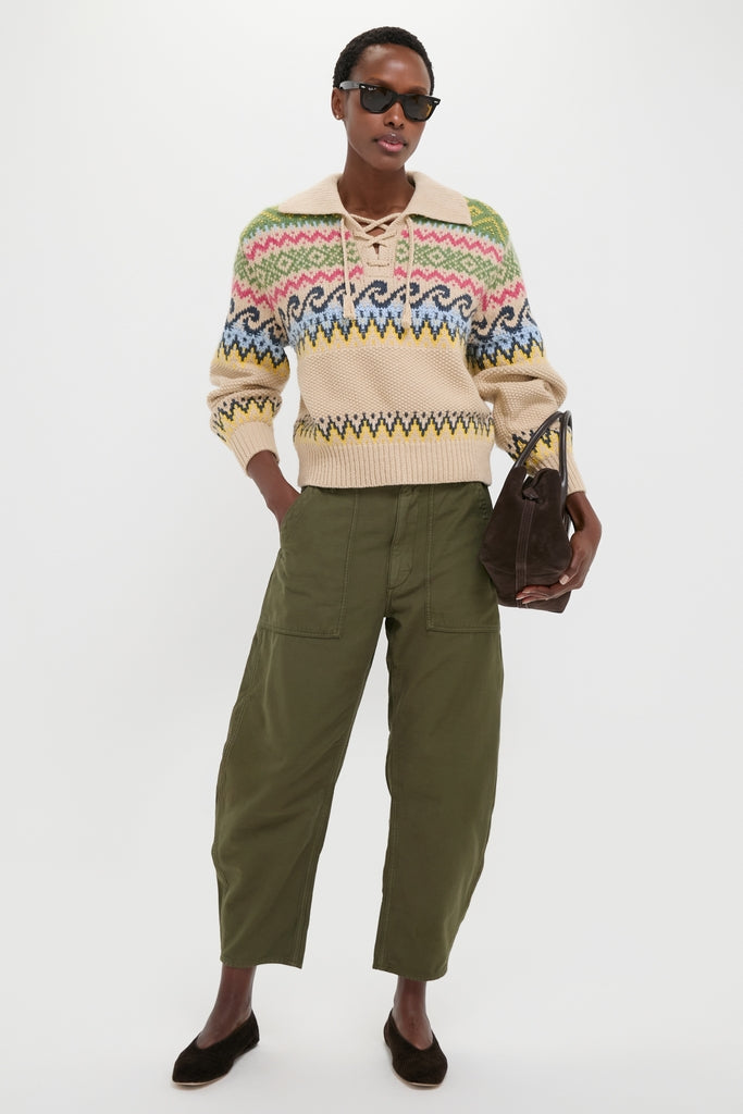 Model wearing classic Dark Olive Reverse Sateen Woven Ankle Tapered Pants, featuring a relaxed fit and adjustable waist, paired with a chic knit sweater and suede handbag.