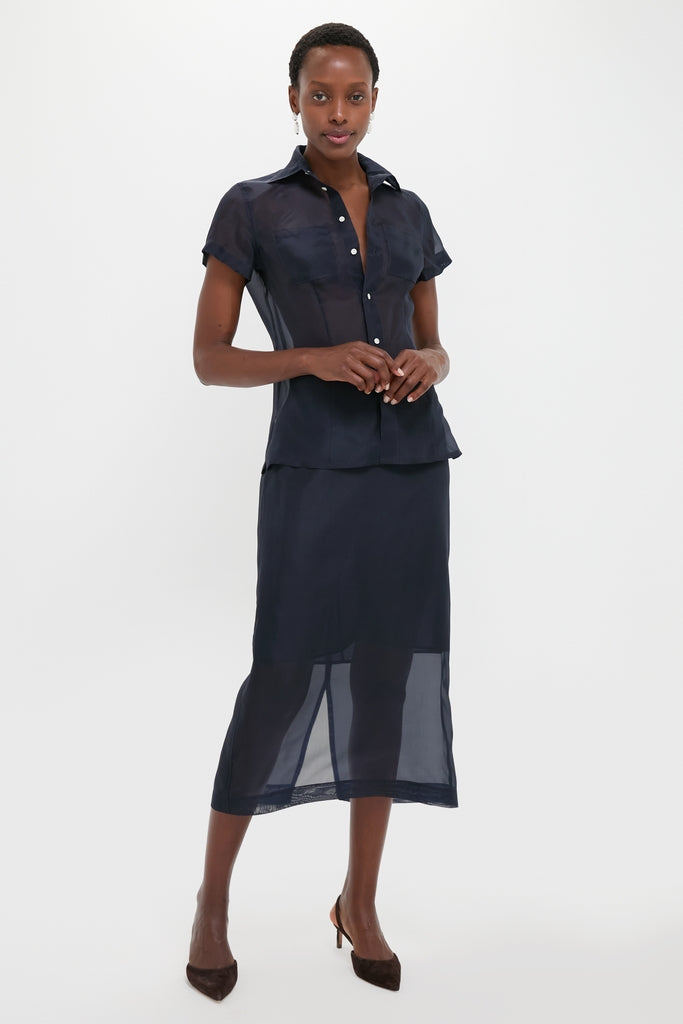Woman wearing the classic Atlantic Silk Organza Woven Midi Pencil Skirt, effortlessly styled with a matching blouse and pumps, embodying fun and high-end sophistication.