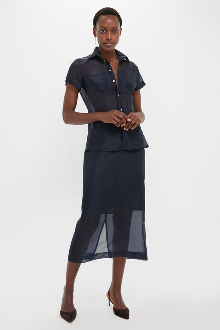 Woman wearing the classic Atlantic Silk Organza Woven Midi Pencil Skirt, effortlessly styled with a matching blouse and pumps, embodying fun and high-end sophistication.