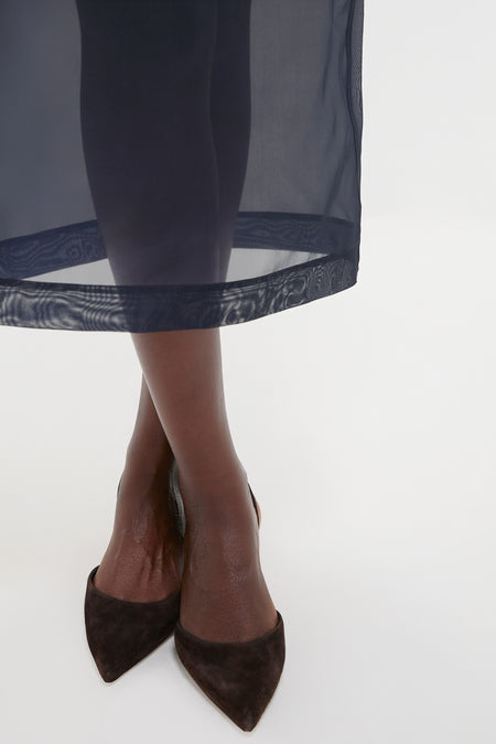Atlantic Silk Organza Woven Midi Pencil Skirt, featuring an effortless, classic silhouette with knee-length lining and vented hem, paired with chic black suede heels.