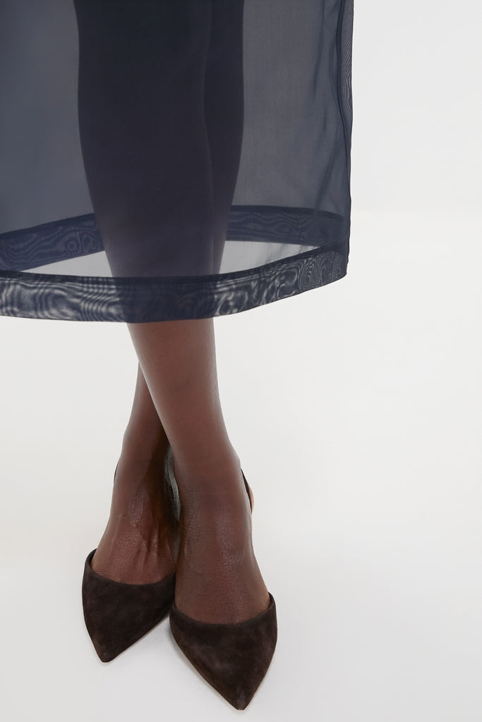 Atlantic Silk Organza Woven Midi Pencil Skirt, featuring an effortless, classic silhouette with knee-length lining and vented hem, paired with chic black suede heels.