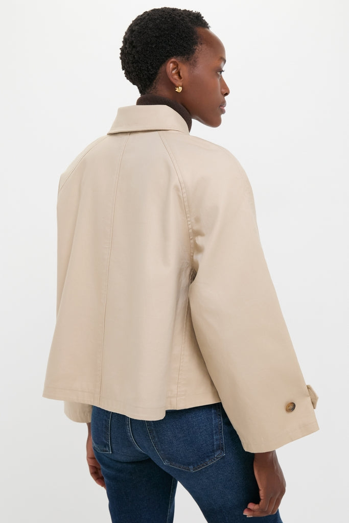Person wearing a classic, high-end Beige Cotton Double Cloth Woven Jacket over a dark turtleneck and blue jeans, exuding effortless style and fun sophistication.