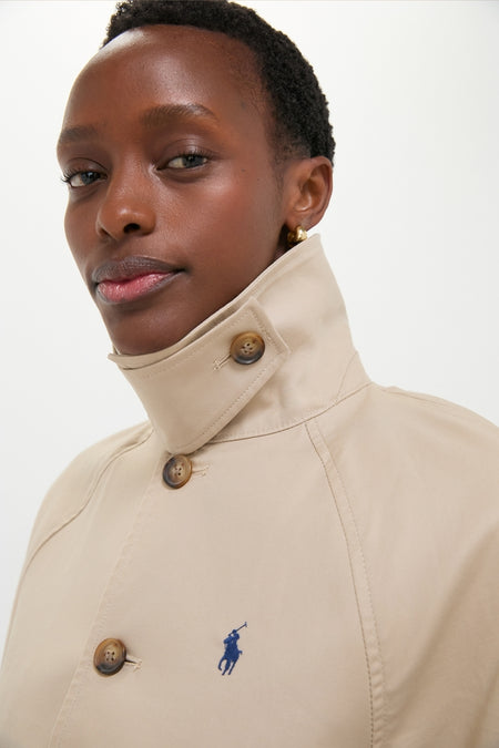 Model wearing a classic Beige Cotton Double Cloth Woven Jacket with tortoiseshell buttons and blue polo-player logo, embodying effortless, high-end style.