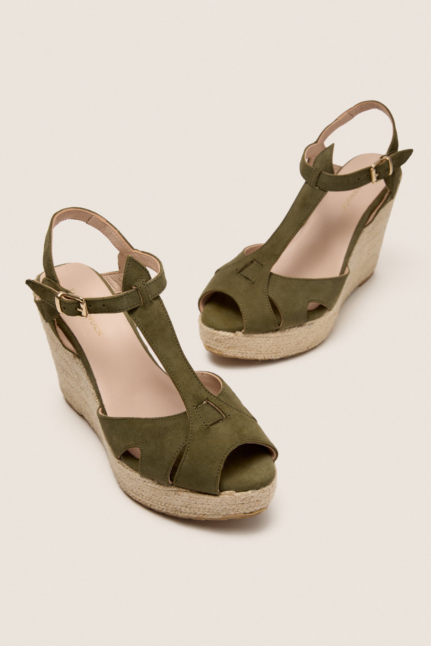 Clover Suede Jules Espadrilles feature classic olive-green suede T-straps, a fun jute wedge, and adjustable gold buckles for an effortlessly high-end look.