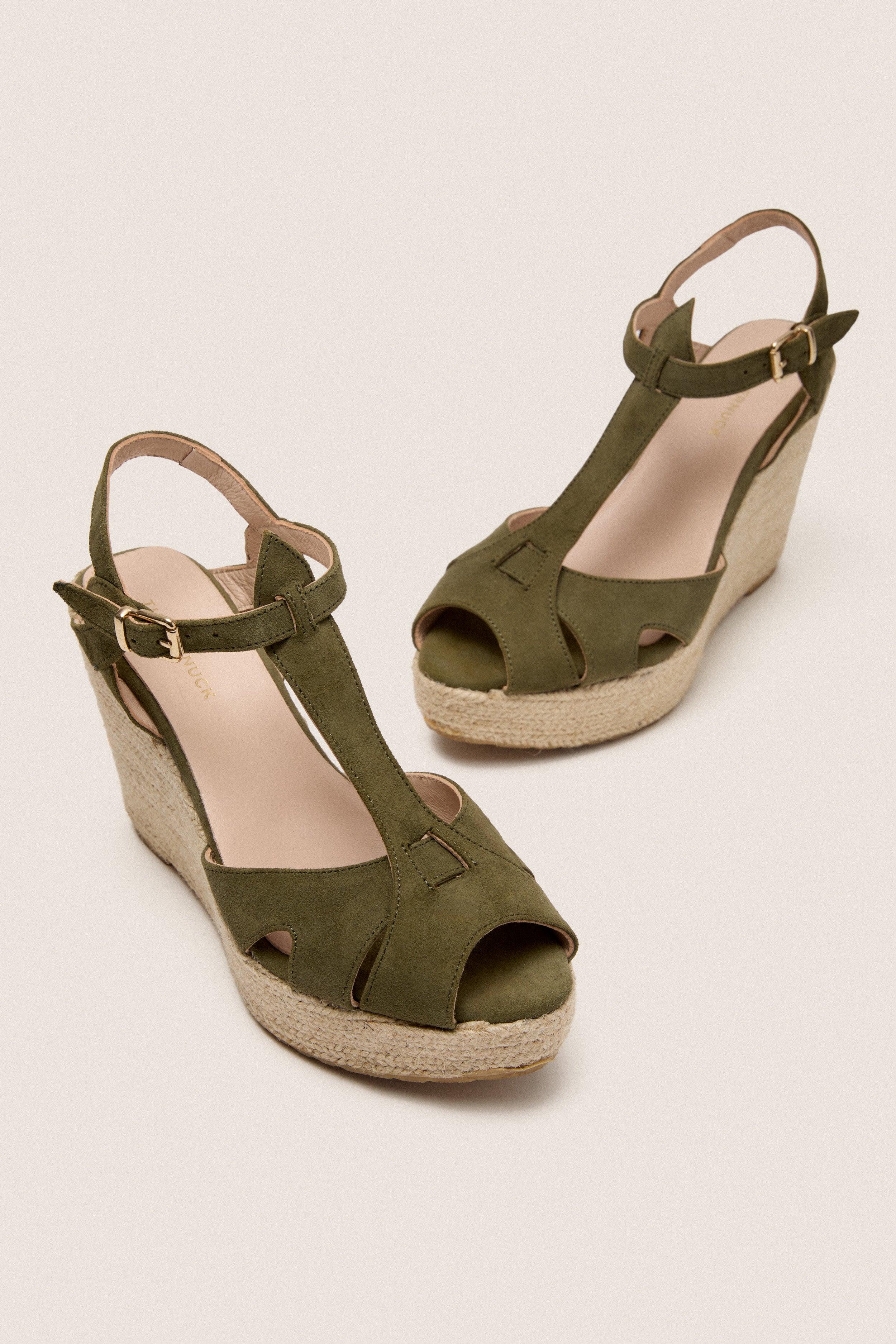 Clover Suede Jules Espadrilles feature classic olive-green suede T-straps, a fun jute wedge, and adjustable gold buckles for an effortlessly high-end look.