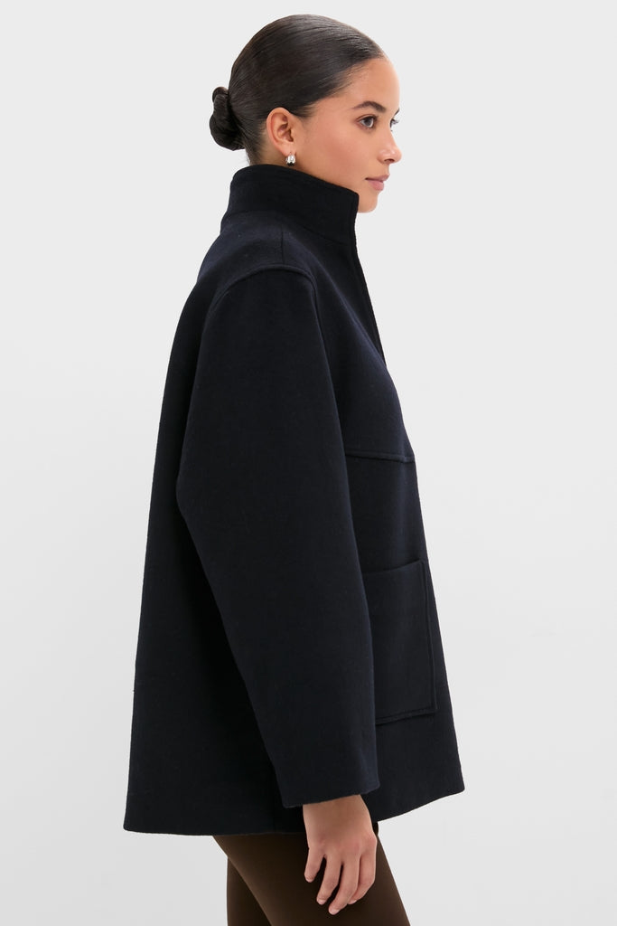 Person wearing the Navy Wool Joan Coat with a classic stand-up collar and oversized fit, featuring large patch pockets—an effortless, high-end piece from Tuckernuck.