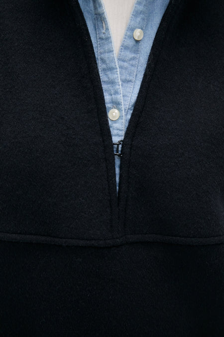 Navy Wool Joan Coat, a classic high-end piece, layered effortlessly over a light-blue button-down, showcasing its fun and unique metal clasp detail.