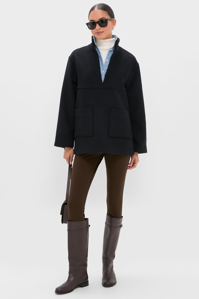 Model in Navy Wool Joan Coat over layered tops, styled with slim-fit pants and riding boots. Accessories add effortless, high-end flair. Classic and fun look.