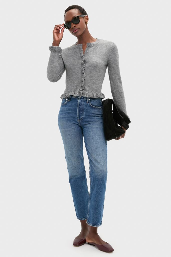 Model in classic, effortless style wearing the Grey Knit Patterson Ruffle Sweater with ruffle trim, paired with cropped jeans and burgundy flats, exuding a fun, high-end look.