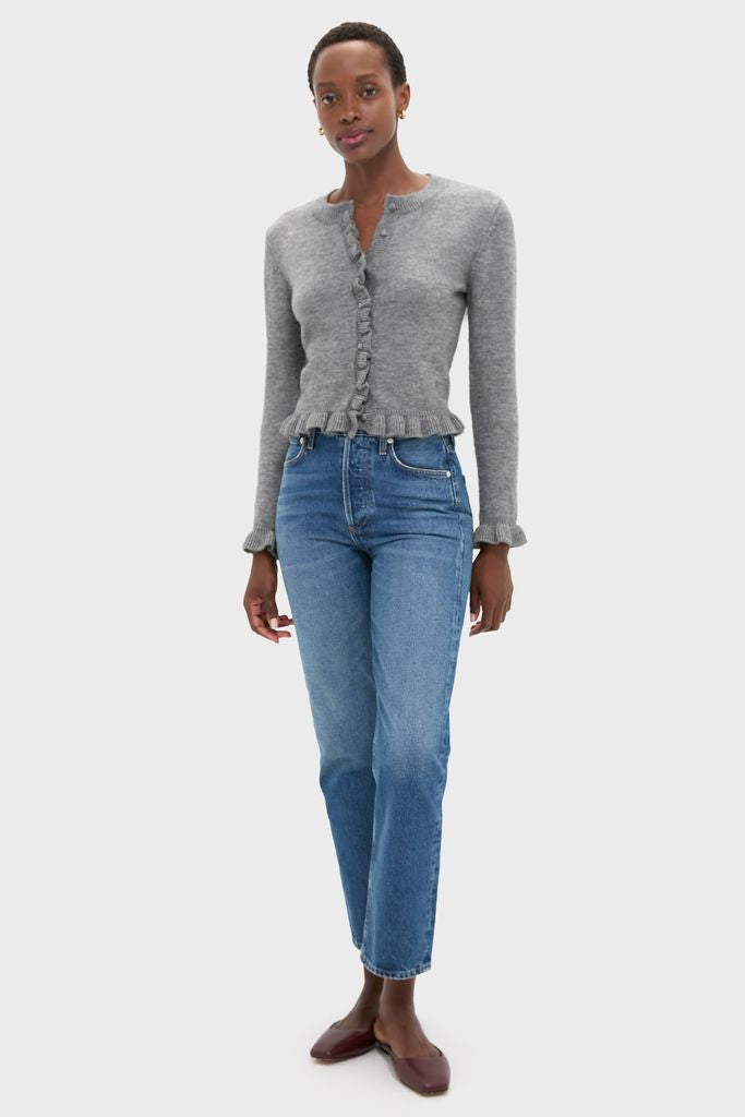 Model wearing the classic Grey Knit Patterson Ruffle Sweater with ruffle trim and self-covered buttons, paired effortlessly with high-rise jeans and burgundy flats for a fun, high-end look.
