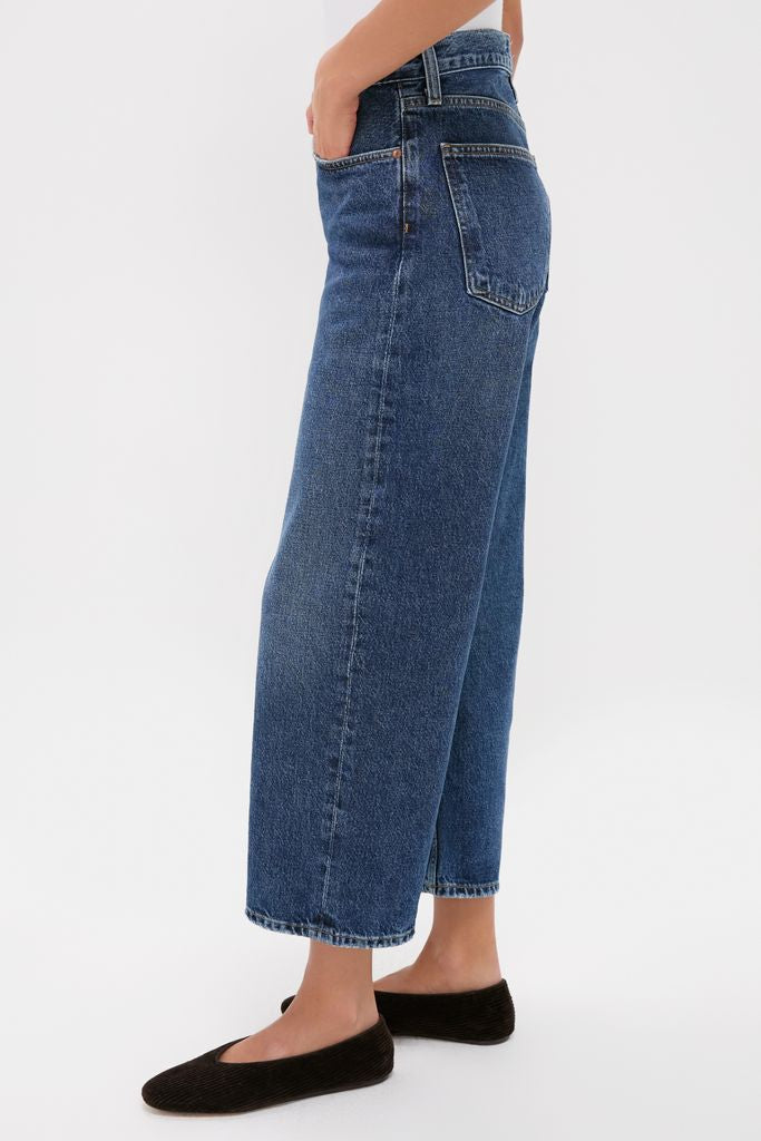 Person wearing classic Shortwave Arc Jean with high-waisted, straight-leg fit and black slip-on flats, embodying effortless, high-end style against a plain white background.