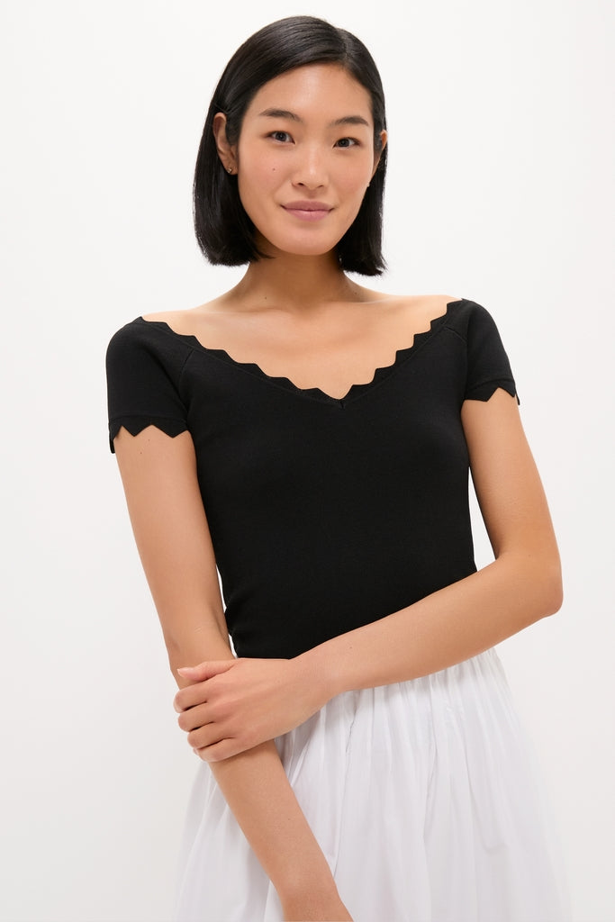 Young woman models a classic, high-end Black Off-the-Shoulder Ric Rac Compression Elliston Shirt, showcasing its effortless, chic fit and fun ric-rac detailing.